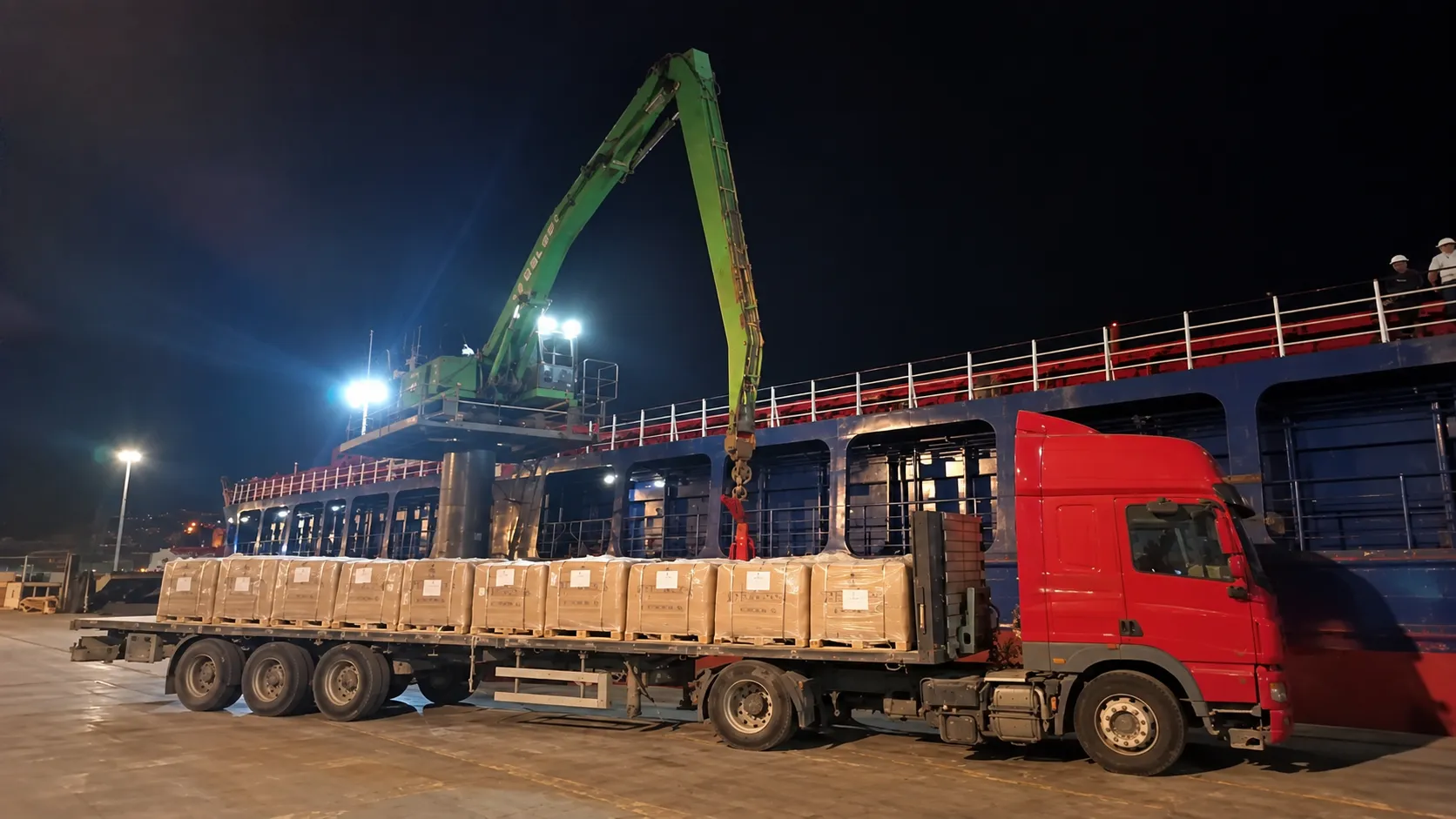Palletised cargo operation alongside a vessel at night